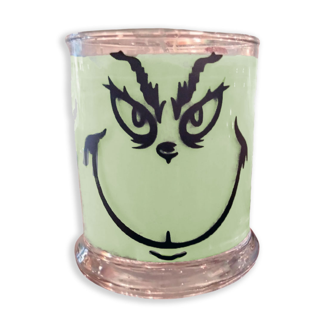 Green Spa Grinch Candle in the glass with face sticker